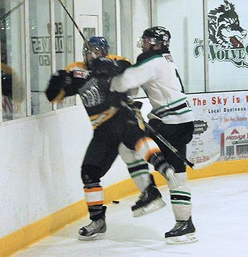 Devin Kemp (R) of the Wolves, checks a Milverton player into the boards